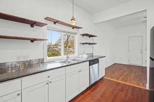 Kitchen featuring open shelves, white cabinets, dark wood-style floors, stainless steel appliances, and ornamental molding