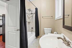 Bathroom with a sink and shower / bath combination with curtain