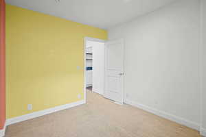 Unfurnished room with light colored carpet and baseboards