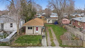 View of front of house with a residential view, a fenced front yard, covered porch, and a shingled roof
