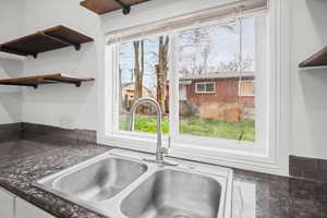 Kitchen view of open shelves and white cabinetry