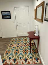 Entryway featuring baseboards and dark wood-style flooring