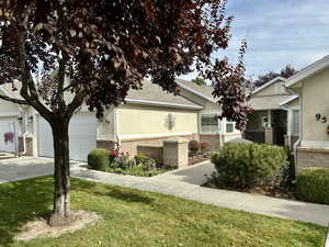 View of home's exterior featuring roof with shingles, brick siding, stucco siding, an attached garage, and concrete driveway