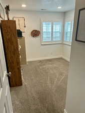 Bedroom featuring dark carpet, a closet, and a textured ceiling