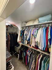 Walk in closet featuring dark colored carpet