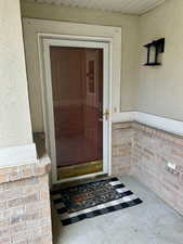 View of exterior entry with brick and stucco