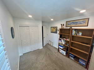 Bedroom featuring dark carpet, a closet, and a textured ceiling