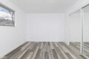 Unfurnished bedroom featuring light wood finished floors and a closet