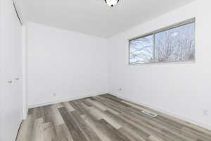 Unfurnished room with light wood-style floors and baseboards
