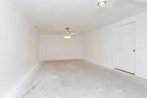Empty room featuring unfinished concrete floors and ceiling fan