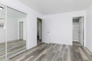 Unfurnished bedroom with light wood-type flooring and ensuite bath