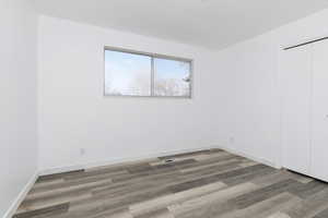Unfurnished room featuring wood finished floors and baseboards