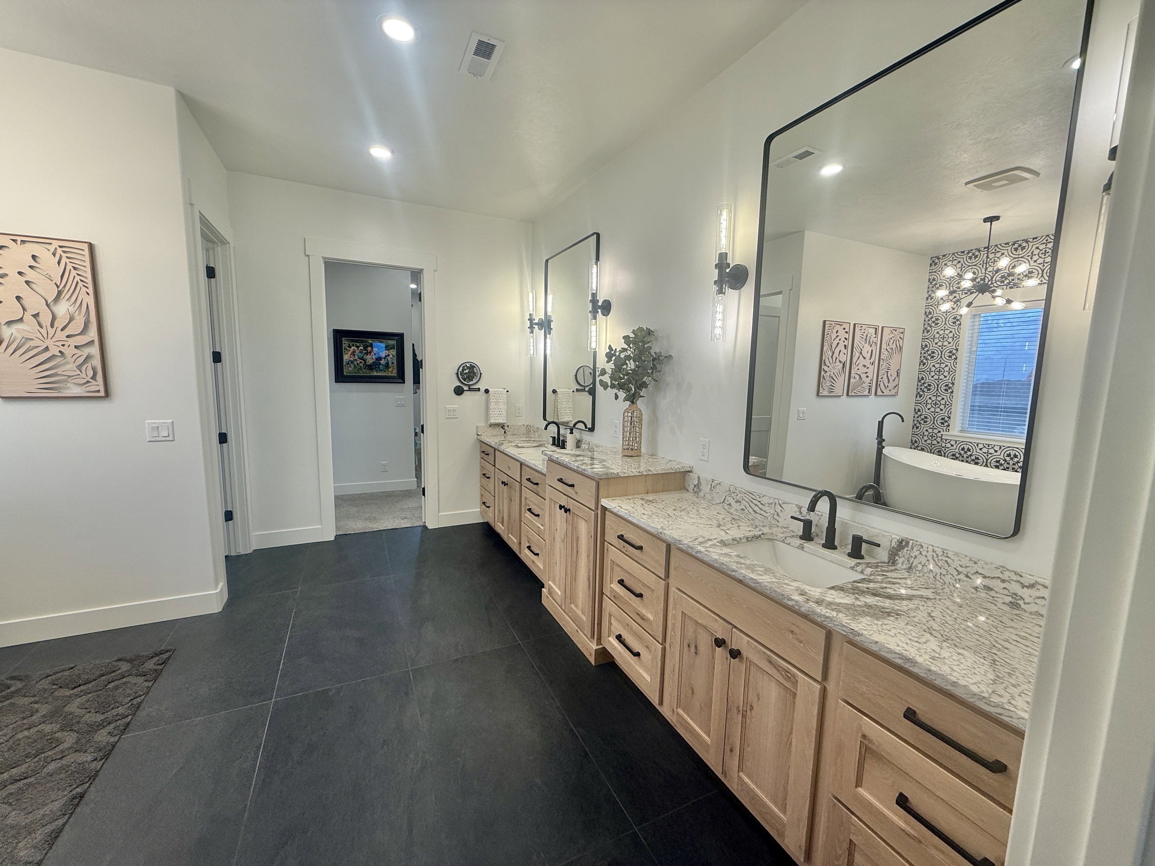 Bathroom featuring double vanity, hanging lights, and a freestanding bath