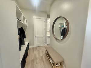 Mudroom featuring light wood-style flooring and baseboards