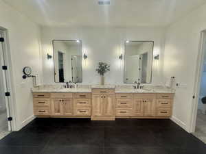 Bathroom with vanity and dark tile patterned flooring