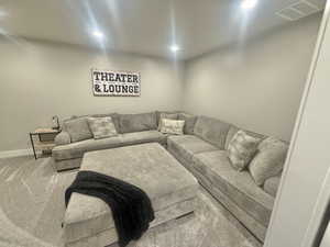 Carpeted living room with recessed lighting and baseboards