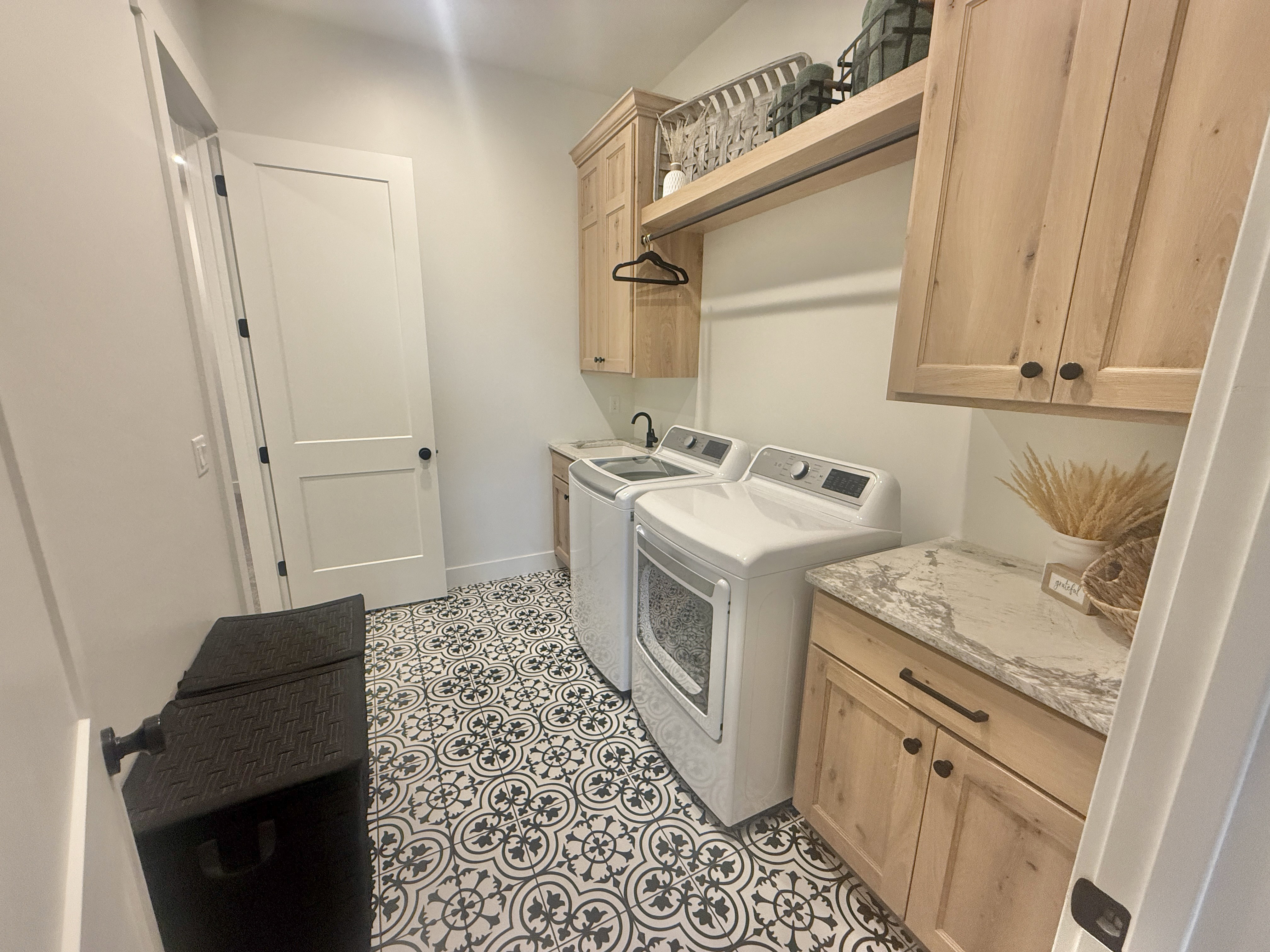 Laundry area with cabinet space, independent washer and dryer, and light tile patterned floors