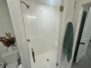 Full bath with a shower stall and toilet
