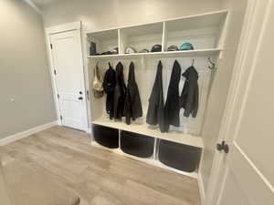 Mudroom with light wood-style flooring and baseboards