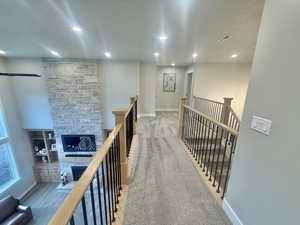 Hallway featuring light carpet, an upstairs landing, and recessed lighting