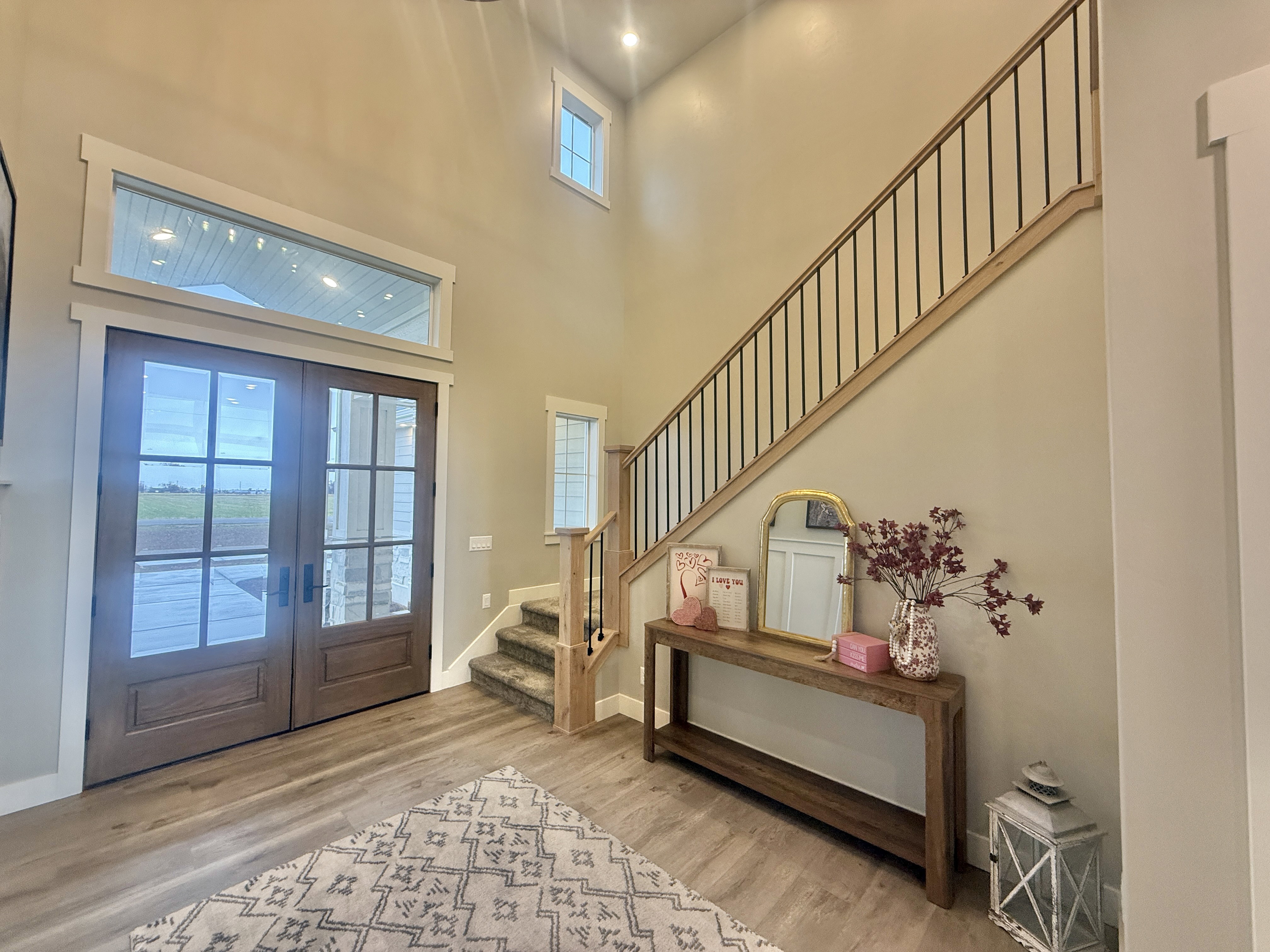 Foyer entrance with french doors, light wood-type flooring, and a high ceiling
