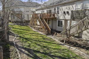 View of green lawn with stairway and a wooden deck