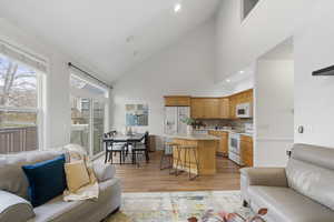 Living area featuring lofted ceiling, light wood-style floors, and recessed lighting