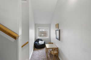 Hall featuring carpet flooring and lofted ceiling