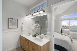 Primary bathroom with double vanity, walk in shower, healthy amount of natural light