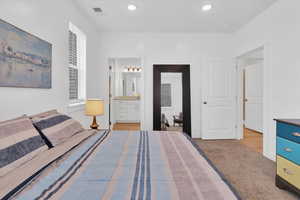 Primary Bedroom featuring light carpet, connected bathroom, and recessed lighting