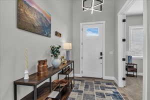 Entryway with baseboards and hanging lights