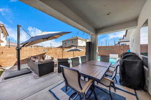 Fenced backyard featuring a patio, outdoor lounge area, and a grill