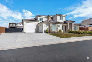 Prairie-style home featuring stucco siding, a garage, concrete driveway, and stone siding