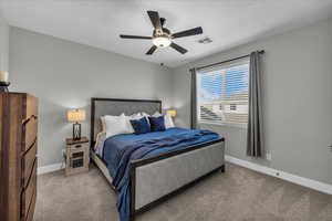 Bedroom with a ceiling fan and light carpet
