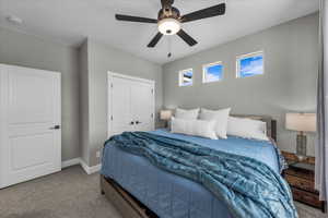 Bedroom featuring carpet floors, ceiling fan, and a closet
