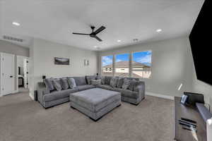 Living area featuring ceiling fan, light carpet, and recessed lighting