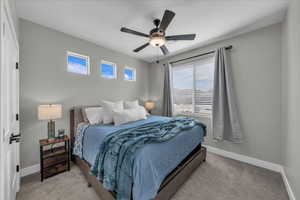 Bedroom with ceiling fan and light carpet
