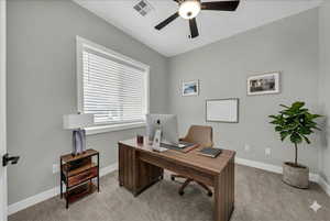 Office area featuring a ceiling fan and light carpet