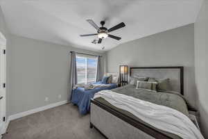 Bedroom featuring vaulted ceiling, ceiling fan, and carpet
