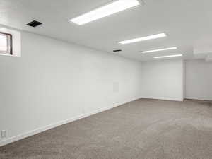 Carpeted spare room with baseboards