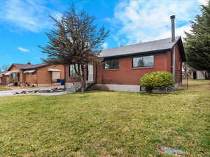 Ranch-style house featuring brick siding, a front lawn, and a shingled roof