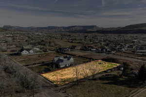 Aerial perspective of suburban area with property parcel outlined and a mountain backdrop