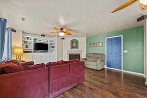 Warm and inviting family room with beautiful flooring, built-in shelving, and cozy fireplace.
