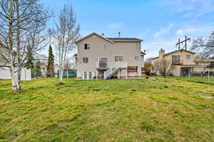 Large backyard with deck access, mature trees, and plenty of space for outdoor living and play.