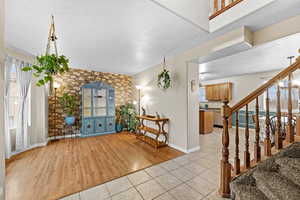 Bright and inviting living room featuring warm flooring and charming accent wall.