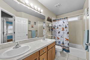 Full bathroom with double sinks and tub/shower combination.