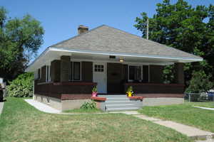 Bungalow featuring a porch, brick siding, a chimney, and roof with shingles
