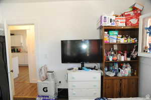 Bedroom with refrigerator and wood finished floors