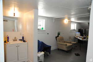 Basement featuring a sink and freestanding refrigerator