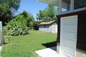 View of green lawn with a storage shed